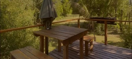 El deck privado con la mesa de madera y la parrilla