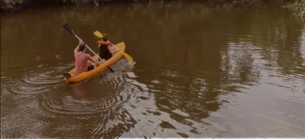 Dos personas en kayak por el río marrón